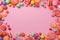 Sweets galore candy frame with vibrant lollipops on pink background