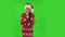 Sweety girl in Santa Claus hat communicates with someone in a friendly manner. Green screen