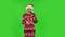 Sweety girl in Santa Claus hat is laughing and having fun. Green screen