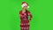 Sweety girl in Santa Claus hat threatens with a fist. Green screen