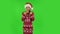 Sweety girl in Santa Claus hat is waving hand and showing gesture come here. Green screen