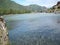 Swift water flow in mountain river with small village in background