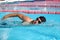 Swim competition swimmer athlete doing crawl stroke in swimming pool. Sports man male swimmer with goggles and cap