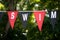 Swim pennant sign, outdoors hanging banner, tree background, close-up, full frame
