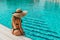 Swim young woman. Young sexy girl in Sun hat, bikini swimsuit, sunglasses relaxing in blue pool water. Swimming pool water, having