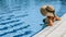 Swim young woman. Young sexy girl in Sun hat, bikini swimsuit, sunglasses relaxing in blue pool water. Swimming pool water, having