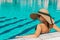 Swim young woman. Young sexy girl in Sun hat, bikini swimsuit, sunglasses relaxing in blue pool water. Swimming pool water, having