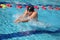 Swimmer in cap breathing performing the breaststroke