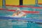 Swimmer child swims breaststroke swimming style in the pool