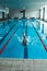 The swimmer pushes off the edge of the swimming pool. woman athlete jumps into the water indoors. Stopping in motion. View from