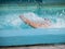 Swimmer splashing water in a blue swimming pool