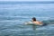 Swimmer swims on the surface of the water in the sea on sunny day