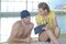 Swimmer talking to coach by poolside at leisure center