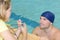 Swimmer talking to coach by poolside at leisure center