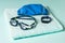 Swimming accessories on a blue towel on a blue background.