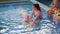 Swimming coach teaches children to swim with foam dumbbells for swimming in pool