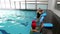 Swimming coach teaching children how to swim