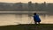 Swimming crawl man and a shooting camera woman at sunset