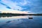 Swimming island in Sweden on a lake at sunset. Clouds reflected in the water