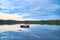 Swimming island in Sweden on a lake at sunset. Clouds reflected in the water