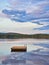 Swimming island in Sweden on a lake at sunset. Clouds reflected in the water