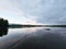 Swimming island in Sweden on a lake at sunset. Clouds reflected in the water