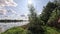 Swimming lake with reflections of the clouds in a light wind and vegetation on the shore