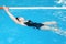 Swimming lessons for children in the pool - beautiful fair-skinned girl swims in the water