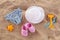 Swimming pool accessories for kids flat lay. Top view of children beach items on sand. Baby flip flops, hat and blue