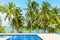 Swimming pool blue water, sea beach poolside, tropical island nature, green palm trees, ocean coast, summer holidays, vacation