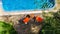 Swimming pool with blue water and sunbed deckchairs aerial top view, tropical vacation hotel resort