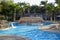 Swimming pool with clear blue water on background of palm trees without people. Sun loungers and umbrellas are located around pool