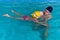 Swimming pool coach teaches a little girl to swim