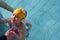 Swimming pool coach teaches a little girl to swim and dive under water