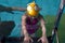 Swimming pool coach teaches a little girl to swim and dive under water