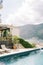 Swimming pool in the courtyard of the villa with soft sun loungers and flowering bushes in tubs on the shore