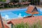 Swimming pool with covered porch and leaves on bottom, shot through tiled roof. Horizontal