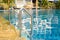 Swimming pool with grab bars ladder and stairs. Green palm trees outside