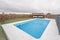 Swimming pool located on the penthouse floor of a residential building with artificial grass surfaces