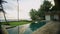 Swimming pool with marble tiles around in backyard of luxury retro villa on tropical ocean island. Ripples on surface of