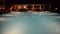 Swimming pool near bar in night illumination at the luxury hotel