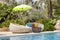 Swimming pool and rattan daybeds in a tropical garden, Thailand