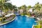 Swimming pool in residential garden with waterfall and chairs