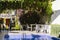 Swimming pool in a resort with terrace. Chairs and table on the patio. Blooming plants and flowers