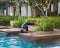 Swimming pool scene during golden hours with children jumping in motion blurry foreground