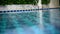 Swimming pool with stairs and wooden deck at luxury hotel. blue pool with blurry water