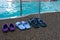 Swimming pool. Three pairs of rubber slippers standing next to each other - men`s, women`s and children`s. Family subscription