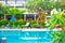 Swimming pool in tropical Asia. Clean water for swimming, sun loungers for relaxation and tropical plants in the