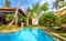 Swimming pool in tropical hotel or house. Panoramic scenic view of Idyllic courtyard