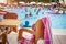 Swimming pool in tropical resort hotel. table with chairs on blurred background of bathing tourists in the pool